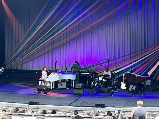 Norah Jones plays the piano onstage with her band