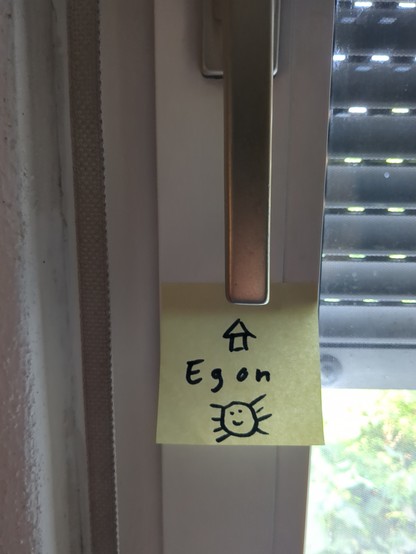 Ein Post-It hängt an einem Fenster. Darauf ein Pfeil nach oben, darunter steht 