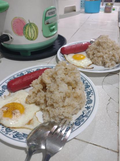Two plates of hotsilog (hotdog + fried rice + fried egg)