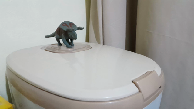 dinosaur toy on a rice bin