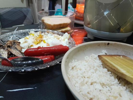 table of Filipino breakfast: fried tuyo fish, fried eggs, hotdogs, fried rice